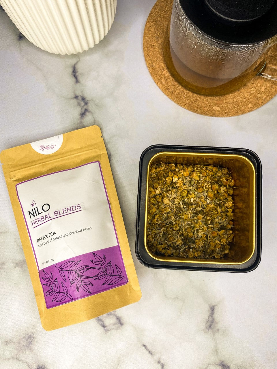 Relax tea product in purple package with loose leaf herbs and a mug of tea